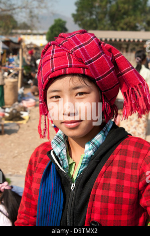 Junge Pa-O Frau rot tragen überprüft die traditionelle Kopfbedeckung lächeln in die Kamera in einem Markt, Myanmar (Birma) Stockfoto