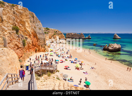 Urlauber, die Sonnenbaden am Praia da Dona Ana Lagos Algarve Portugal EU Europa Stockfoto