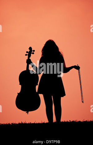 Ein Mädchen mit einem Cello Silhouette gegen einen hellen Himmel Stockfoto