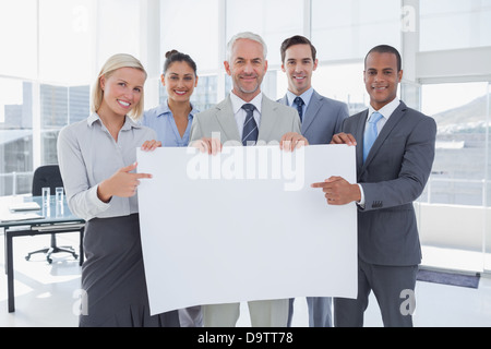 Business-Team hält große leeres Plakat und darauf Stockfoto