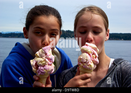 Zwei hübsche junge Mädchen Verkostung gegenseitig ihre riesigen Eis Zapfen, Campbell River BC Kanada Entdeckung Fishing Pier Stockfoto