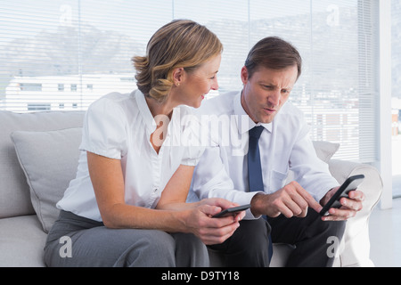 Attraktive Geschäftsmann zeigen etwas auf seinem Handy einer Geschäftsfrau Stockfoto