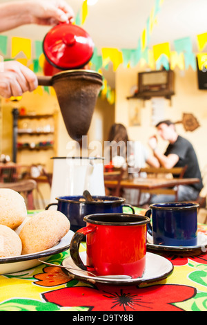 Bunte Becher auf einen Tisch und Kaffee, die Entwässerung durch einen Stoff-Filter im Hintergrund. Stockfoto