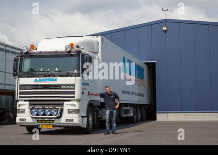 LKW-Fahrer und DAF XF LKW vor einem Dock in den Niederlanden Stockfoto