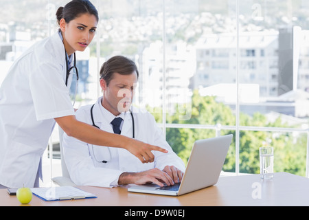 Arzt auf dem Laptop eines Kollegen zeigen Stockfoto