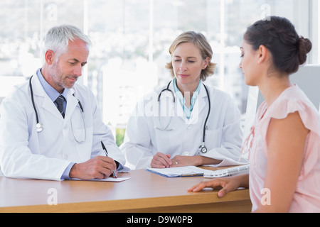 Zwei Ärzte mit einer Patientin Stockfoto