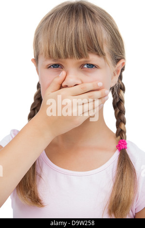 Kleines blondes Mädchen mit der Hand auf den Mund Stockfoto