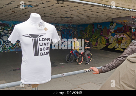 Ein langes Leben South Bank Kampagne T-shirt in der Unterkirche. Im Hintergrund sind zwei BMX-Fahrer. Stockfoto