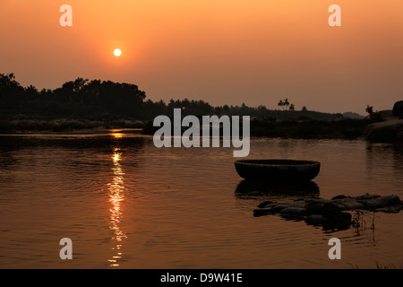 Die untergehende Sonne über der Überquerung des Flusses in Hampi. Stockfoto