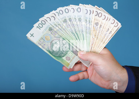 Das Unternehmer Hand mit Polnisch Geld Banknote blau Hintergrund Stockfoto