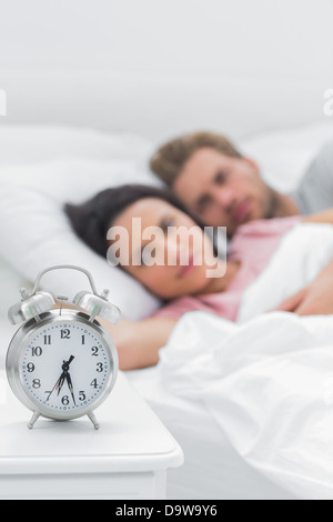 Paar liegend in ihrem Bett neben Wecker Stockfoto