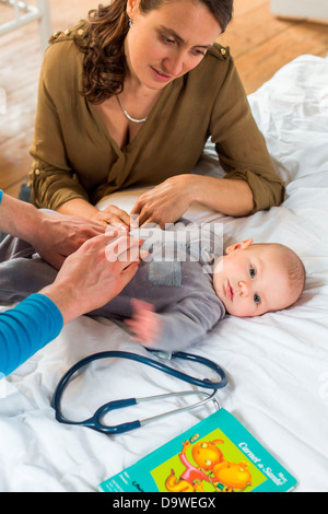 Arzt Abtasten des Bauches ein 5 Monate altes Baby junge Stockfoto