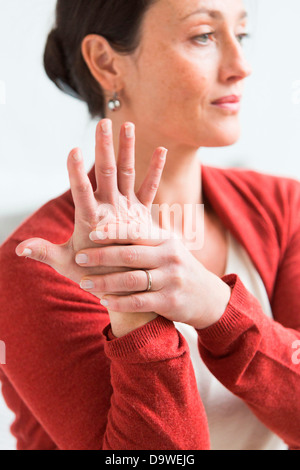 Frau geben sich selbst eine Hand massage Stockfoto