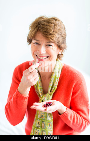 Ältere Frau Essen getrocknete cranberries Stockfoto