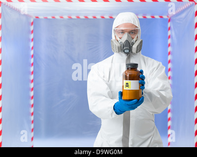 Nahaufnahme des Menschen tragen von Schutzausrüstung halten Sie eine Flasche mit der Bezeichnung als tödliche Substanz in einer Kammer Surounde mit roten und weißen Band Stockfoto