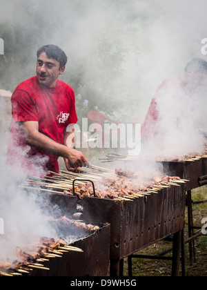 Georgier vorbereiten eines ihrer nationalen Gerichte, Mtsvadi (gegrilltes Fleisch aufgespießt), auf der junge Weinfestival in Tiflis. Stockfoto