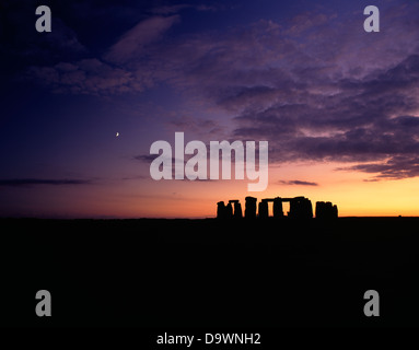 Eine weite Landschaft Blick auf die Stonehenge Trilithons Silhouette nach Sonnenuntergang und Mondaufgang. Wiltshire, England Stockfoto