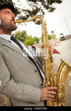 männliche Straßenmusiker spielen Saxophon Stockfoto