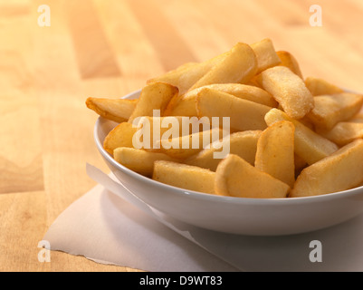 Pommes frites in eine Schüssel geben Stockfoto