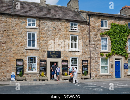 Menschen Touristen Besucher zu Fuß rund um den Marktplatz im Sommer Masham Wensleydale North Yorkshire England Großbritannien GB Groß Großbritannien Stockfoto