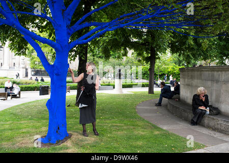 London, UK. 27. Juni 2013. Festival-Gärten, City of London. Menschen interagieren Sie mit einer der Bäume, die als Teil der blauen Bäume in London Kunstinstallation blau gemalt. Nächstenliebe Bäume für Städte gemeinsam mit internationalen Künstler, Konstantin Dimopoulos, kam mit dem Blue Tree-Konzept. Die Idee des Projekts ist es, Menschen zu stoppen und beachten Sie die Bäume im städtischen Umfeld. Wenn Stadtbevölkerung wächst, verringert sich die Anzahl der Bäume in der Stadt. Aber viele Menschen heute um zu betrachten, berühren und Foto eines der blauen Bäume gestoppt. Bildnachweis: Allsorts Stock Foto/Alamy Live-Nachrichten Stockfoto