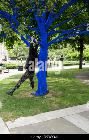 London, UK. 27. Juni 2013. Festival-Gärten, City of London. Menschen interagieren Sie mit einer der Bäume, die als Teil der blauen Bäume in London Kunstinstallation blau gemalt. Nächstenliebe Bäume für Städte gemeinsam mit internationalen Künstler, Konstantin Dimopoulos, kam mit dem Blue Tree-Konzept. Die Idee des Projekts ist es, Menschen zu stoppen und beachten Sie die Bäume im städtischen Umfeld. Wenn Stadtbevölkerung wächst, verringert sich die Anzahl der Bäume in der Stadt. Aber viele Menschen heute um zu betrachten, berühren und Foto eines der blauen Bäume gestoppt. Bildnachweis: Allsorts Stock Foto/Alamy Live-Nachrichten Stockfoto