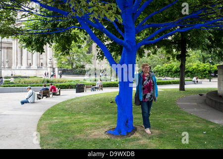 London, UK. 27. Juni 2013. Festival-Gärten, City of London. Menschen interagieren Sie mit einer der Bäume, die als Teil der blauen Bäume in London Kunstinstallation blau gemalt. Nächstenliebe Bäume für Städte gemeinsam mit internationalen Künstler, Konstantin Dimopoulos, kam mit dem Blue Tree-Konzept. Die Idee des Projekts ist es, Menschen zu stoppen und beachten Sie die Bäume im städtischen Umfeld. Wenn Stadtbevölkerung wächst, verringert sich die Anzahl der Bäume in der Stadt. Aber viele Menschen heute um zu betrachten, berühren und Foto eines der blauen Bäume gestoppt. Bildnachweis: Allsorts Stock Foto/Alamy Live-Nachrichten Stockfoto