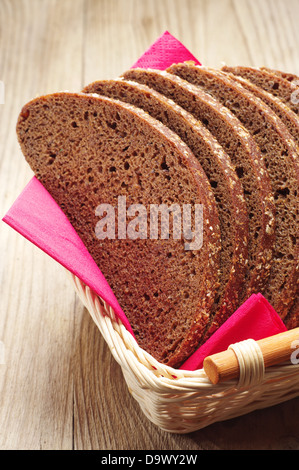 Scheiben Brot in einem Korb auf einem Holztisch Stockfoto
