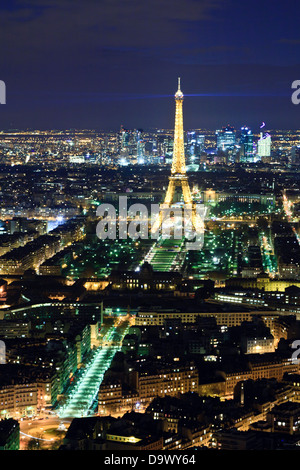 Paris Eiffelturm bei Nacht Blitz oben mit La Défense Geschäftsviertel im Hintergrund Stockfoto