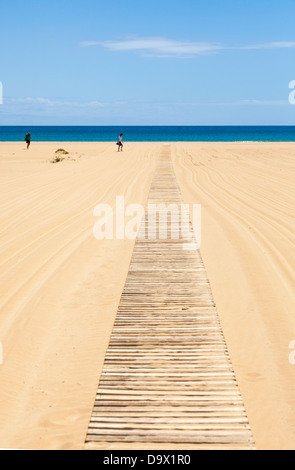 Zwei Menschen, die zu Fuß in Richtung Holzlatte Rollstuhlrampe Strand Zugang. Stockfoto