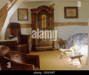 18. Jahrhundert Deutsch Schrank im Land Schlafzimmer mit Leder und antikem Holz Sessel und rustikalen Holztisch lackiert Stockfoto