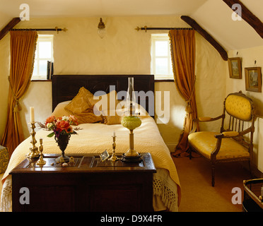Alte Holzkiste am Fuße des Doppelbett mit Creme Bettdecke im Ferienhaus Schlafzimmer mit kleinen Sofa im Regency-Stil Stockfoto