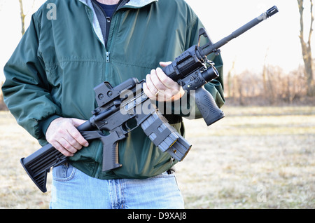 Mann hält AR Stil Gewehr mit Magazin eingefügt. Für die redaktionelle Nutzung. Stockfoto