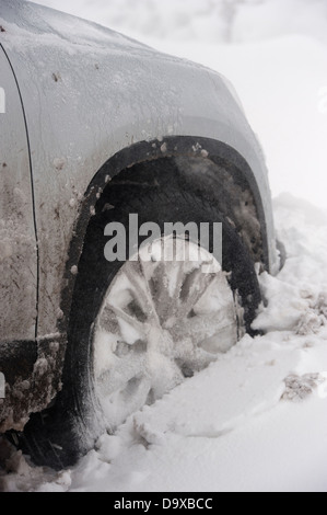 Nahaufnahme von Pkw-Räder in Schneeverwehungen stecken. Stockfoto