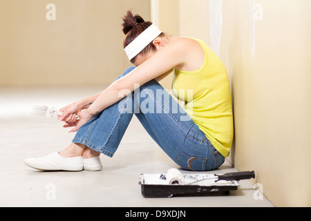 junge Frau müde nach der Lackierung des Hauses Stockfoto