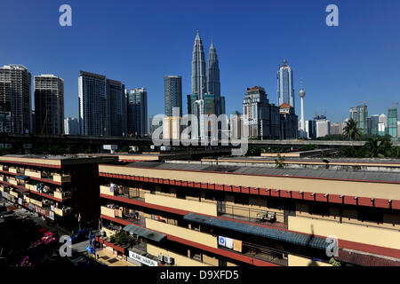 Kuala Lumpur, Malaysia. 28. Juni 2013. Wohngebäude sind Malaysias berühmten Petronas Twin Towers im Hintergrund vor einem blauen Himmel in Kuala Lumpur gesehen. © Najjua Zulkefli/ZUMAPRESS.com/Alamy Live-Nachrichten Stockfoto