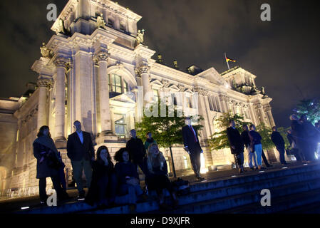 Menschen schauen Sie einen Film und Lichtprojektion Funktionen vor dem Reichstag in Berlin, Deutschland, 27. Juni 2013. Die 30 min Show mit dem Titel "in the German people - eine parlamentarische Spurensuche. Vom Reichstag zum Bundestag "ist jeden Abend auf der Fassade des Marie-Elisabeth-Lueders-Haus bis zum Tag der deutschen Einheit am 3. Oktober 2013 vorgestellt. Foto: Kay Nietfeld Stockfoto