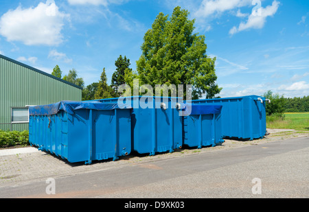 mehrere blaue Container in einer Reihe auf einem Industriegebiet Stockfoto