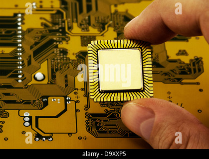 Finger halten einer CPU Stockfoto