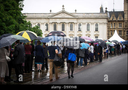 Cambridge, UK. 28. Juni 2013. Eine nasse Abschlusstag für Studenten der Universität Cambridge. Studenten und ihre Familie und Freunde Schlange vor dem Senat-Haus in Cambridge für Grad Zeremonien. Bildnachweis: JAMES LINSELL-CLARK/Alamy Live-Nachrichten Stockfoto