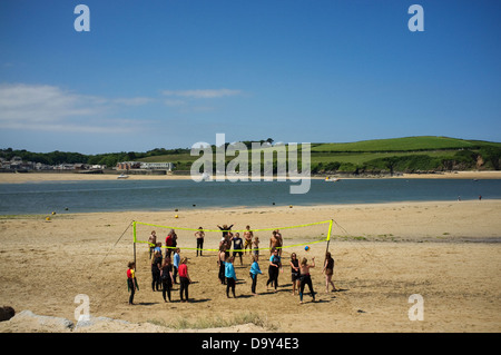 Eine Gruppe junger Menschen spielen Sie Volleyball am Strand von Rock, Cornwall, England, UK. Stockfoto