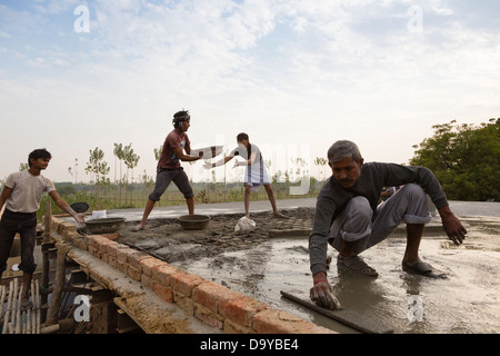 Indien, Uttar Pradesh, Aligarh, Dorfbewohner schwimmenden Zement auf einem Dorf Hausdach Stockfoto