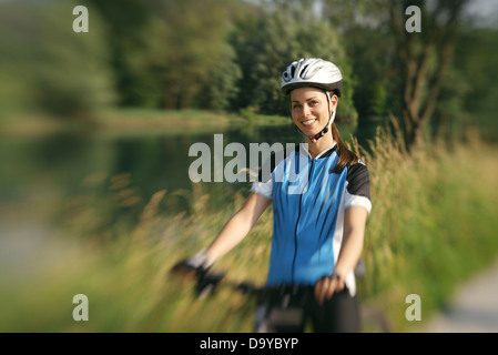 junge Frau training mit Mountainbike und Radfahren im Park. Kopieren Sie Raum, niedrige Winkel Ansicht Stockfoto