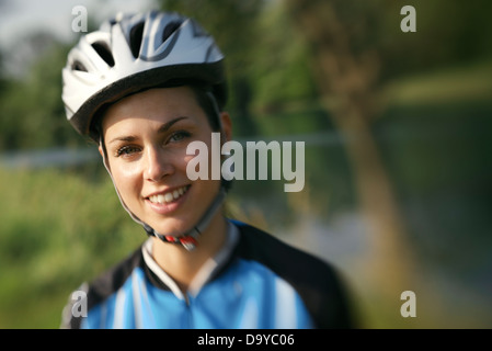 Porträt der jungen Frau auf Mountainbike training und lächelt in die Kamera. Defokussierten Bild Stockfoto