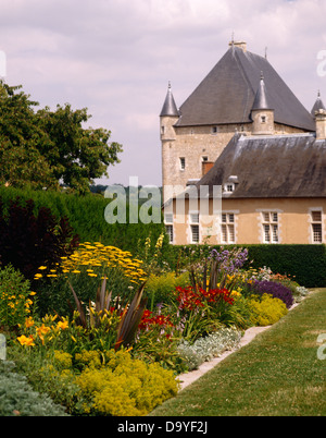 Damen Mantel und gelb jährliche Sonnenblumen in krautigen Grenze mit roten Taglilien im Gelände des französischen Schlosses Stockfoto