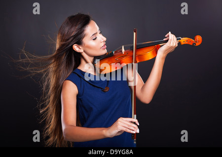 schöne junge Frau Geigenspiel auf schwarzem Hintergrund Stockfoto