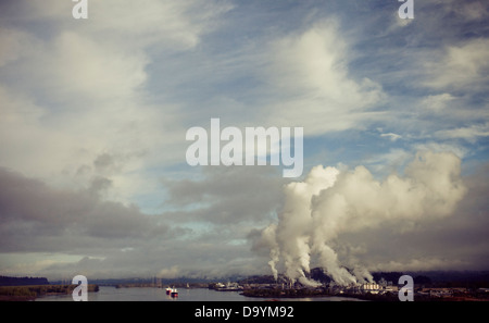 Rauch, Dampf und Umweltverschmutzung steigt von einer Industrieanlage. Stockfoto