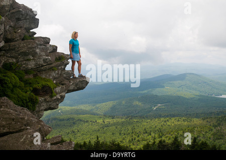 Eine Frau, die in der Ansicht auf einem felsigen Punkt, Großvater Mountain State Park, Linville, North Carolina. Stockfoto