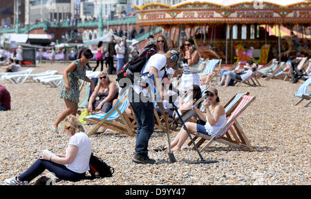 Brighton UK 29. Juni 2013 - eine Schatzsucher mit einem Metalldetektor Gerät geht unter die Sonnenanbeter am Strand von Brighton als sie das warme Wetter genossen heute Foto von Simon Dack/Alamy Live News Stockfoto