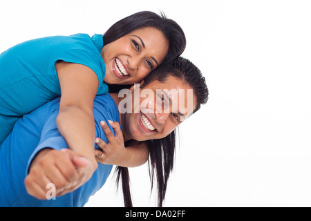 glückliche junge indische Paare, die Spaß mit Piggyback auf weißem Hintergrund Stockfoto